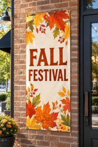 Fall festival vinyl banner hanging on a brick wall beside a shop door